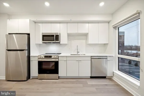 a kitchen with stainless steel appliances granite countertop a stove a sink and a refrigerator