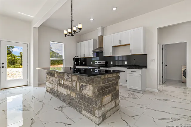 a large kitchen with granite countertop a stove and a sink
