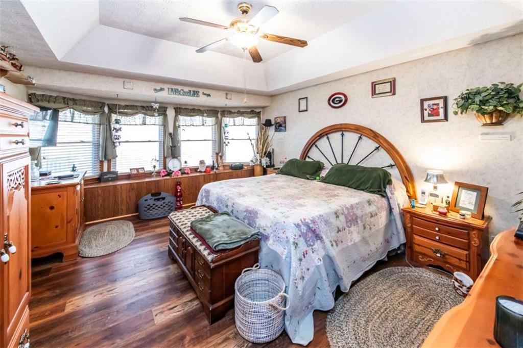 261 Clayton Trail Canton, GA 30114 - Photo 11 of 37 a spacious bedroom with a bed and wooden floor
