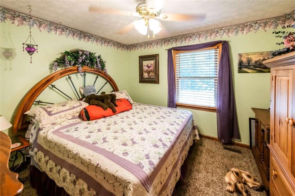 261 Clayton Trail Canton, GA 30114 - Photo 16 of 37 a bed sitting in a bedroom next to a window