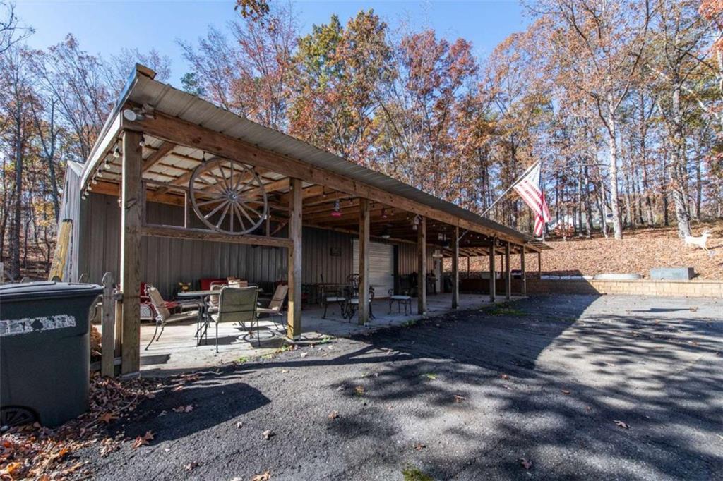 261 Clayton Trail Canton, GA 30114 - Photo 22 of 37 a patio with wooden fence and a lawn chairs under an umbrella