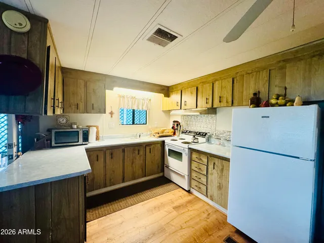 a kitchen with stainless steel appliances granite countertop a refrigerator a stove top oven a sink and dishwasher