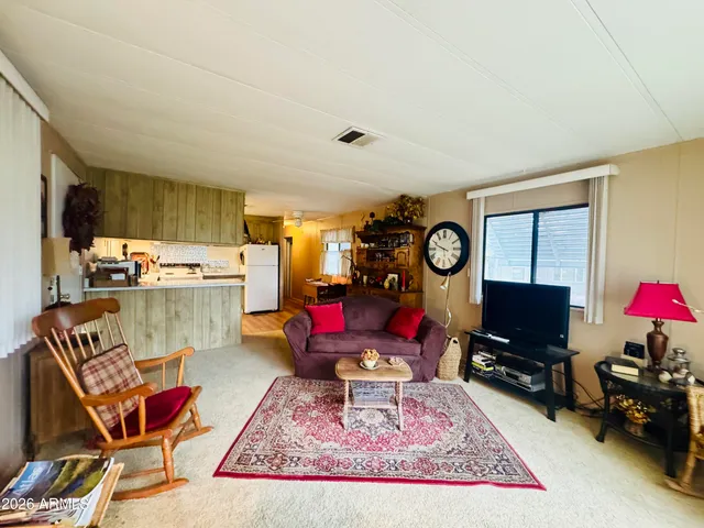a living room with furniture a rug and a flat screen tv