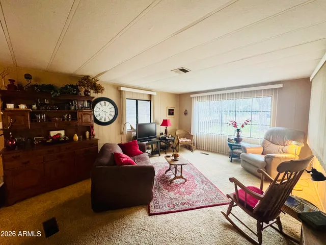 a living room with furniture a mirror and a window