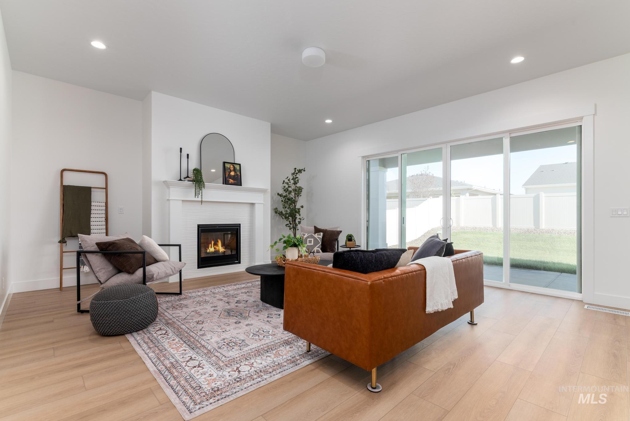 9074 West Moonglade Street Star, ID 83669 - Photo 6 of 40 Living area featuring a white mantle fireplace with black insert, wood-finish flooring, and recessed lighting