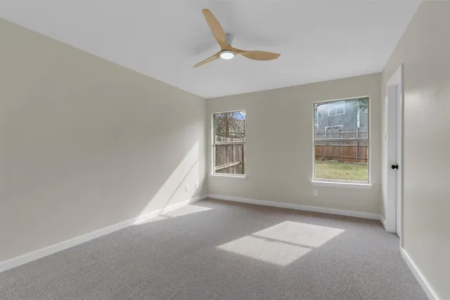 a view of empty room with ceiling fan