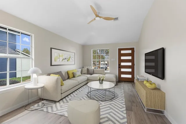 a living room with furniture a window and a flat screen tv