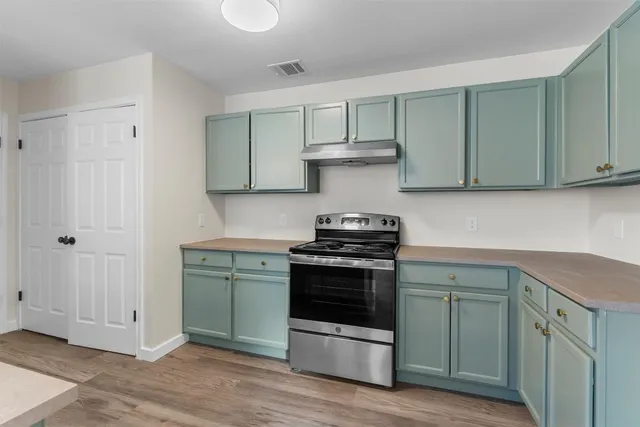 a kitchen with a sink cabinets and wooden floor