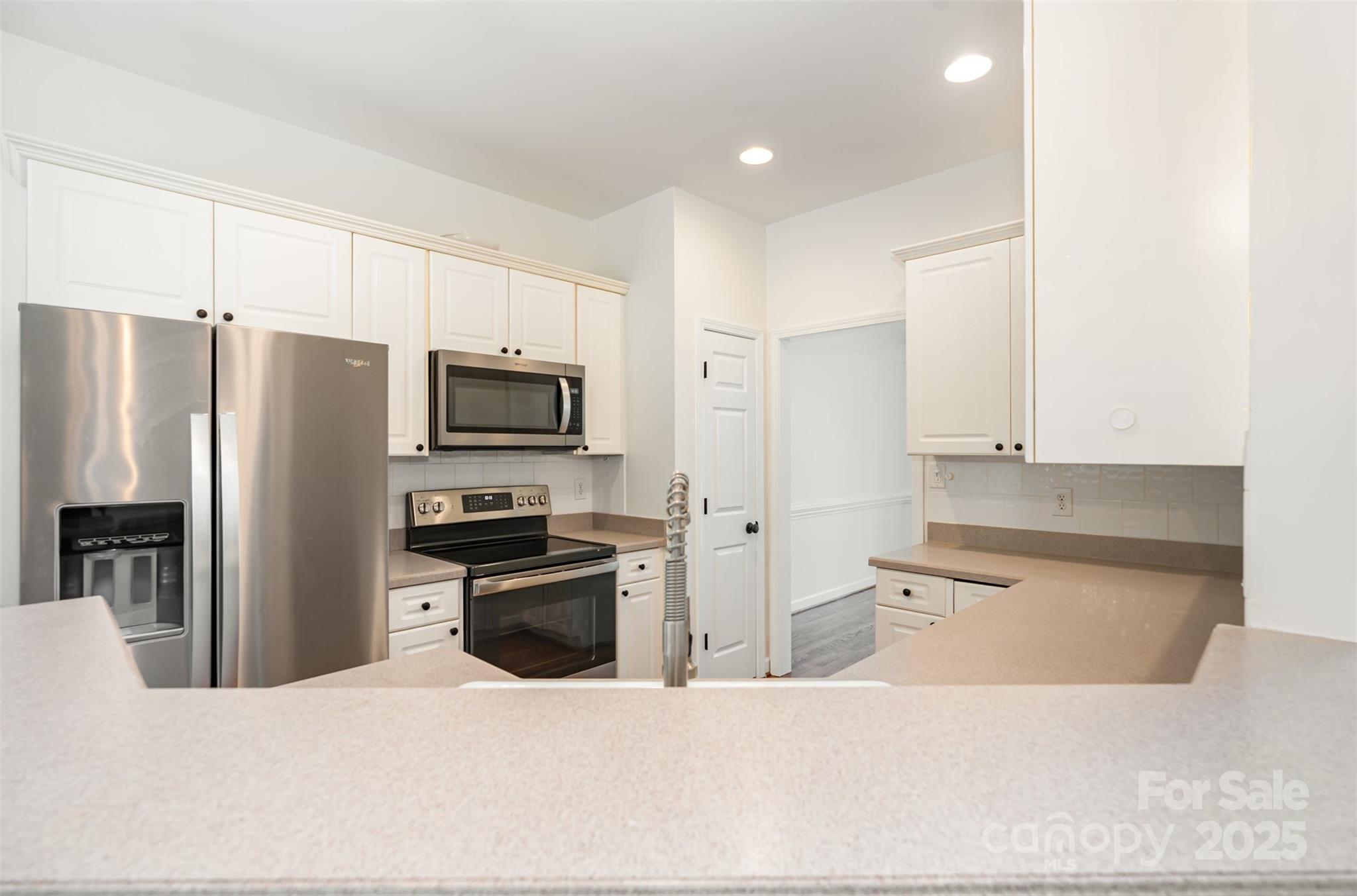 2746 Cameron Commons Way Matthews, NC 28104 - Photo 15 of 38 a kitchen with granite countertop a refrigerator and a stove top oven
