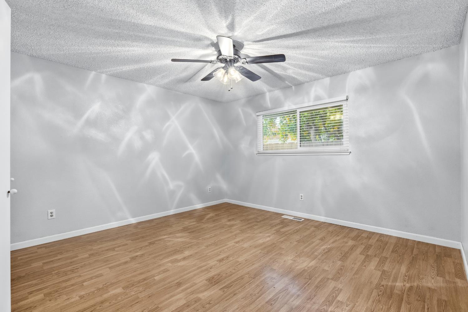 1416 Buttonwillow Drive Modesto, CA 95355 - Photo 26 of 39 an empty room with wooden floor fan and windows