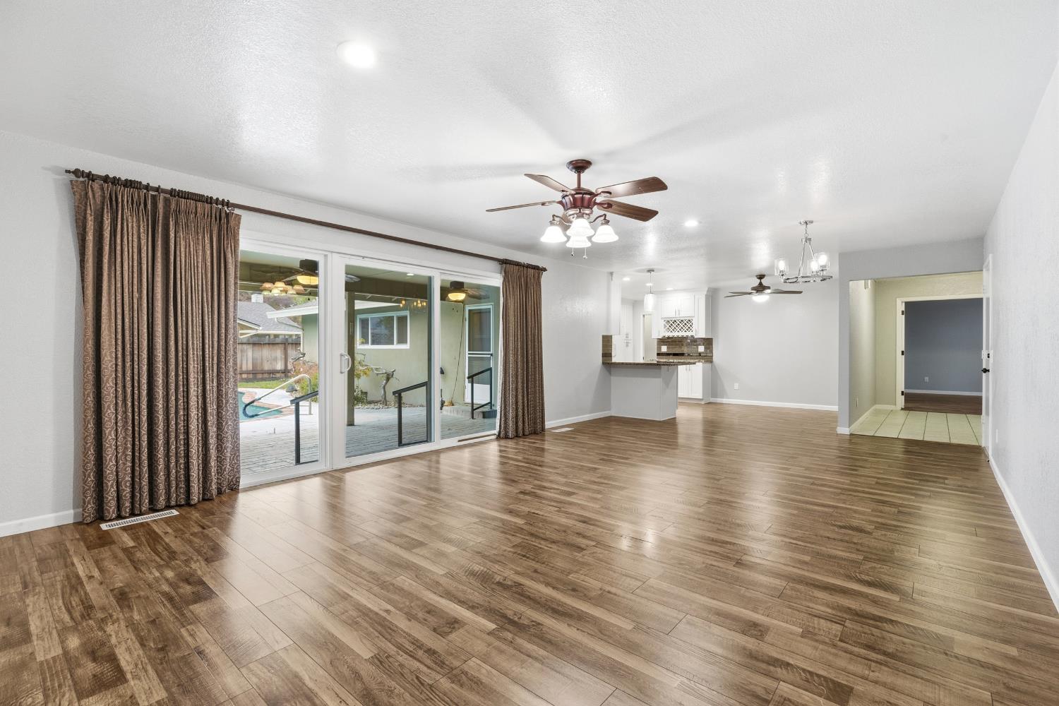 1416 Buttonwillow Drive Modesto, CA 95355 - Photo 6 of 39 a view of an empty room with wooden floor and a window