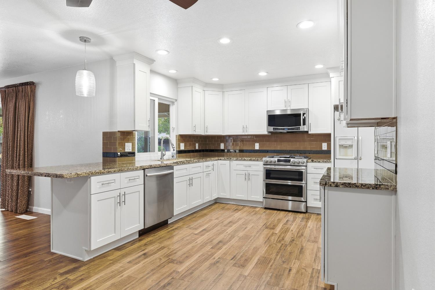 1416 Buttonwillow Drive Modesto, CA 95355 - Photo 8 of 39 a kitchen with granite countertop a stove top oven and cabinets