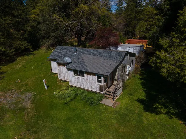 an aerial view of a house with a yard table and chairs