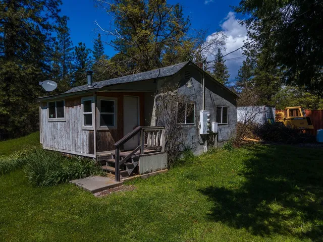 a view of a house with backyard and wooden fence
