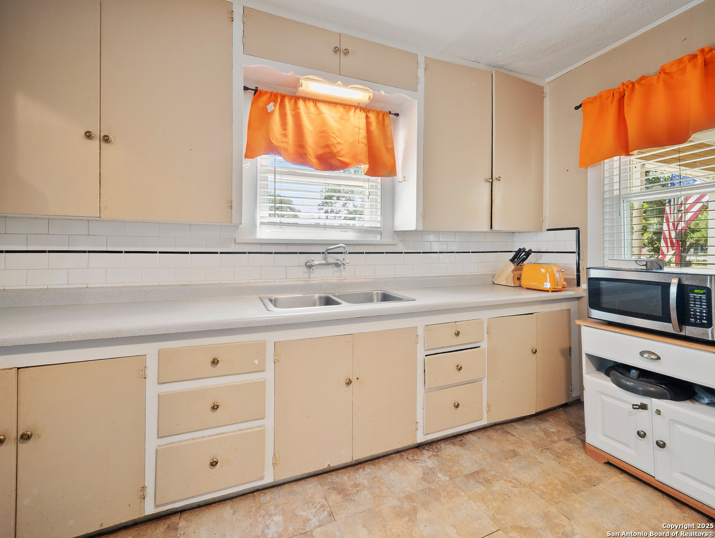 608 Ross Street Kerrville, TX 78028 - Photo 7 of 24 a kitchen with cabinets appliances a sink and a window