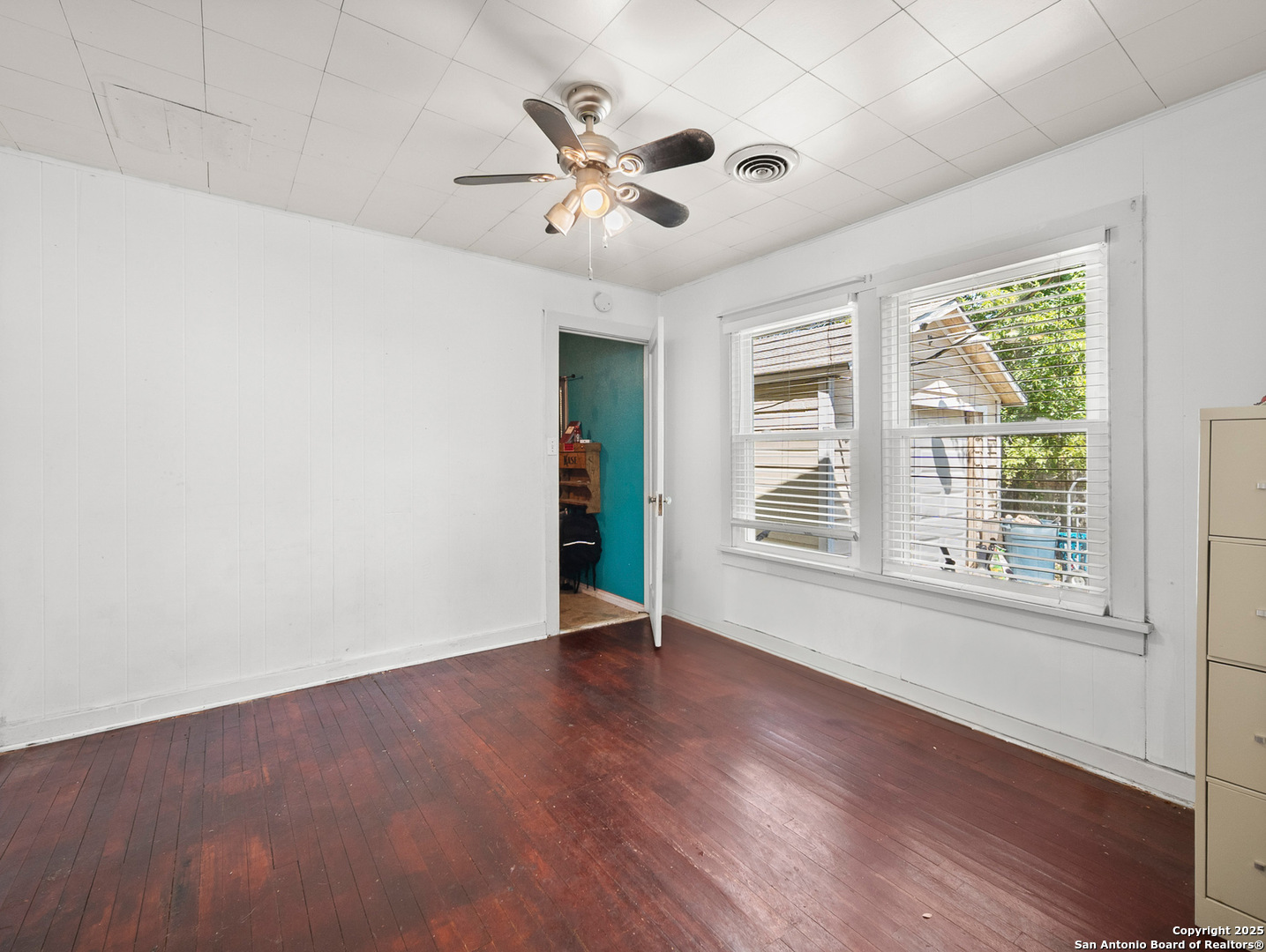 608 Ross Street Kerrville, TX 78028 - Photo 9 of 24 an empty room with wooden floor chandelier fan and windows
