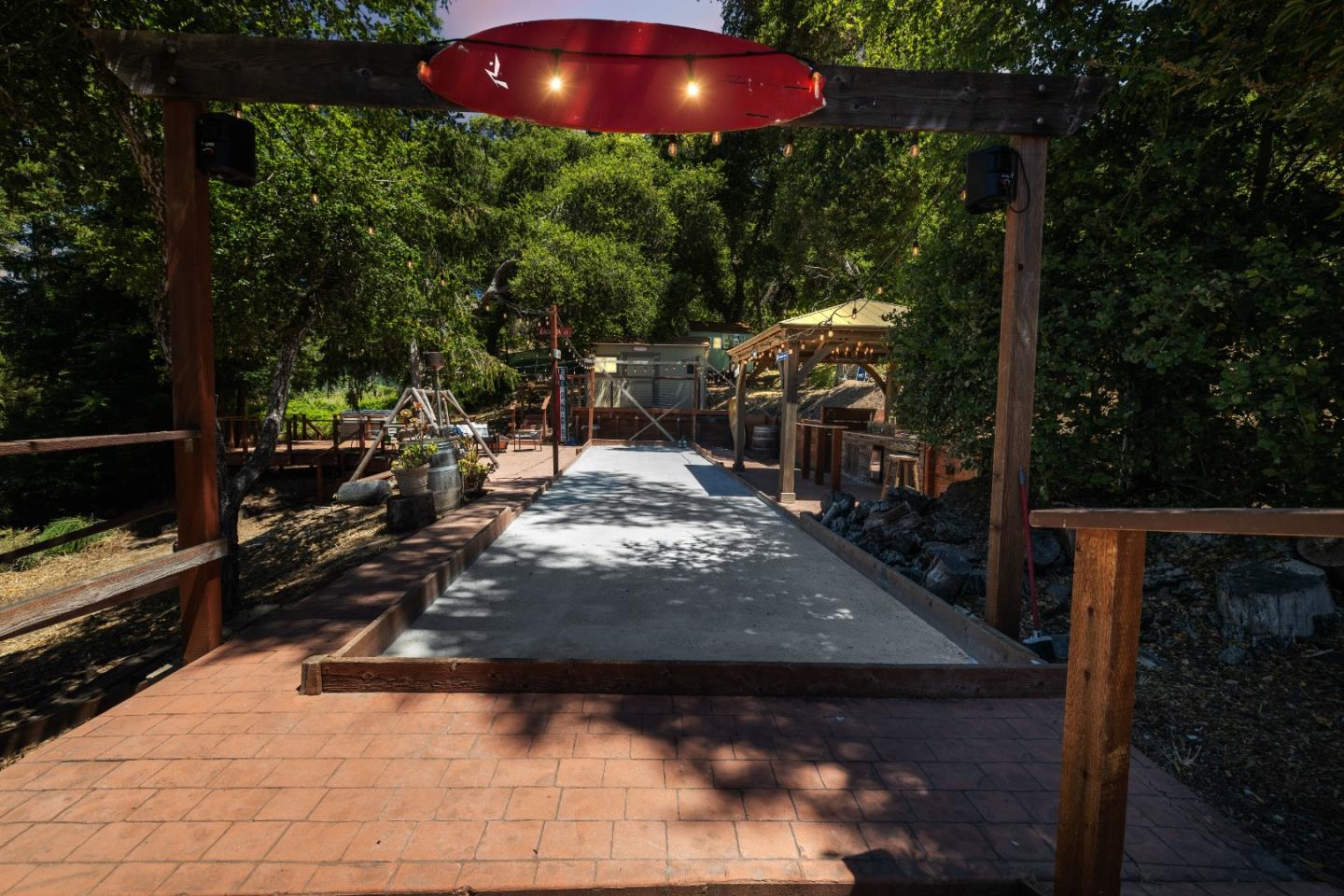 24475 Mountain Charlie Road Los Gatos, CA 95033 - Photo 59 of 69 a view of a patio with table and chairs under an umbrella with a small yard