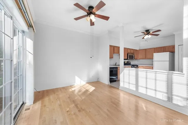 a view of a kitchen with wooden floor and a ceiling fan