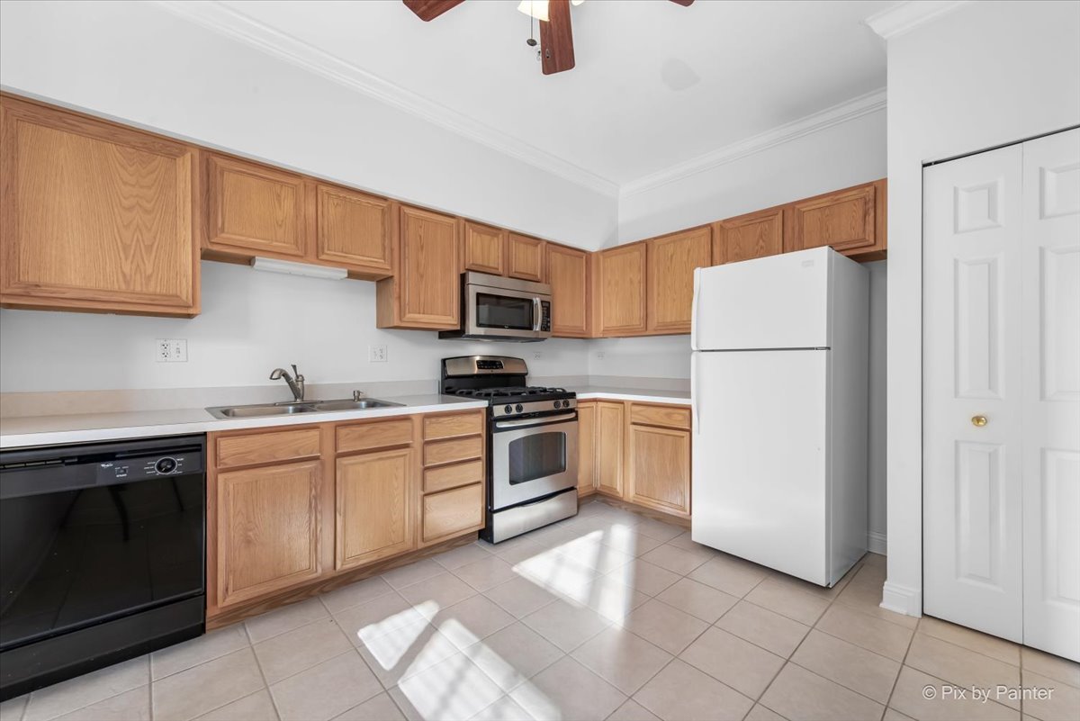 827 Riding Lane, Unit 827 St. Charles, IL 60174 - Photo 14 of 40 a kitchen with a refrigerator sink and cabinets