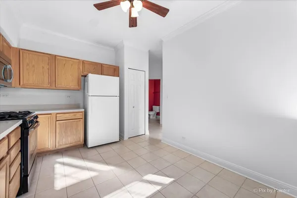 a kitchen with a refrigerator a stove top oven and cabinets