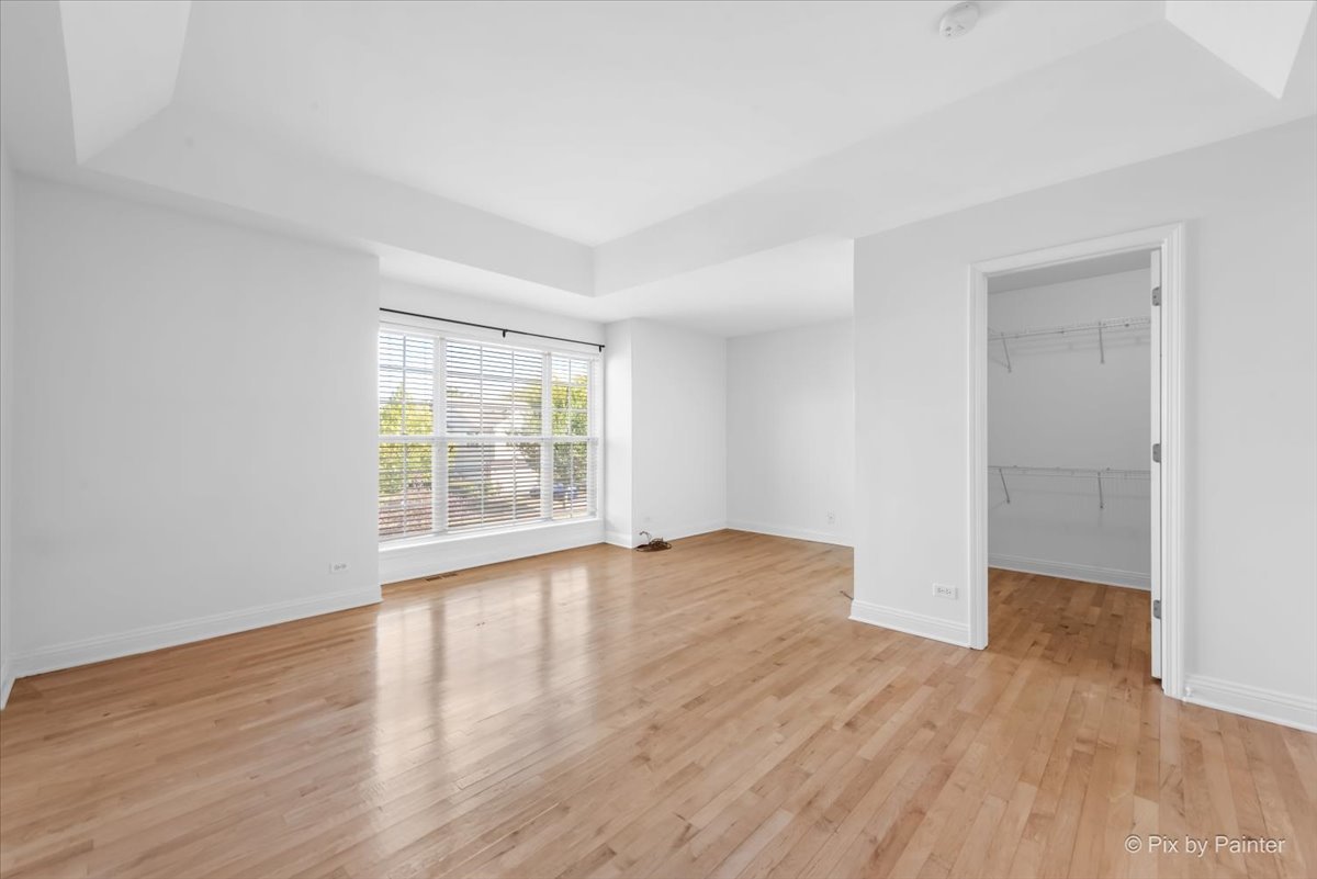 827 Riding Lane, Unit 827 St. Charles, IL 60174 - Photo 20 of 40 a view of an empty room with wooden floor and a window