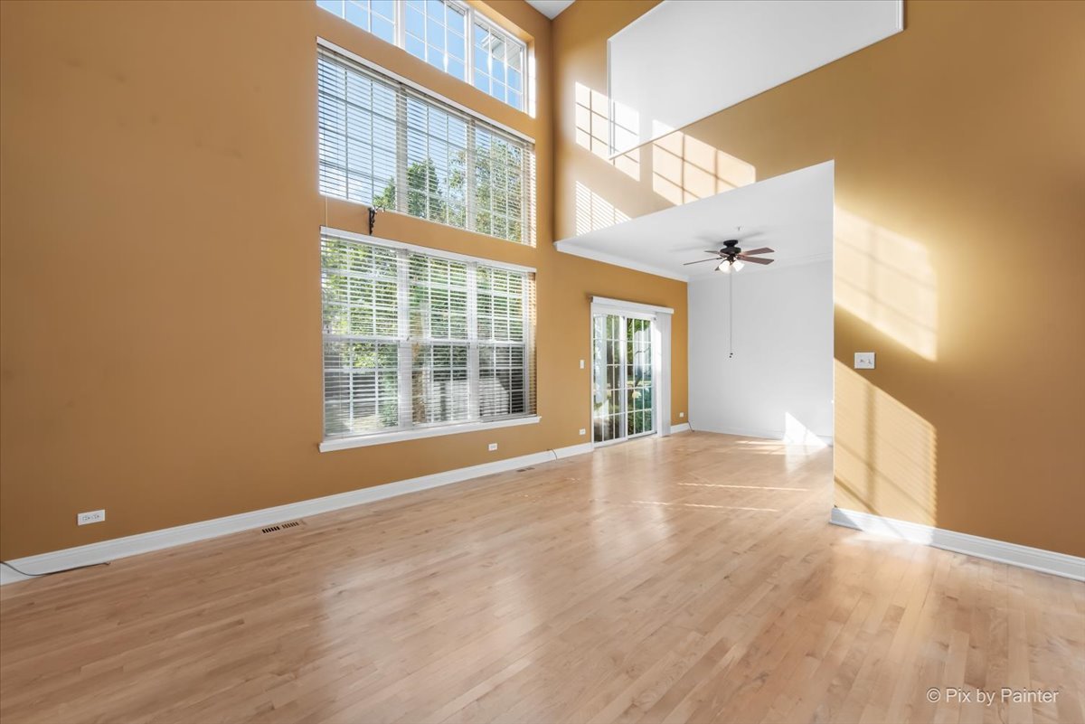 827 Riding Lane, Unit 827 St. Charles, IL 60174 - Photo 7 of 40 a view of an empty room with a window and wooden floor