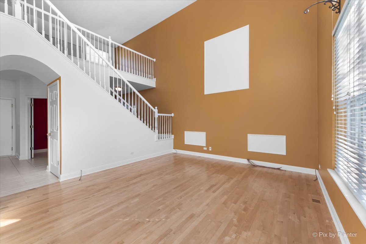 827 Riding Lane, Unit 827 St. Charles, IL 60174 - Photo 8 of 40 a view of an empty room with wooden floor and a window