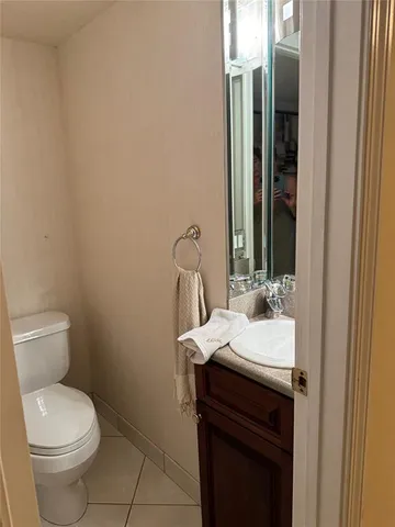 a white toilet sitting next to a sink and vanity