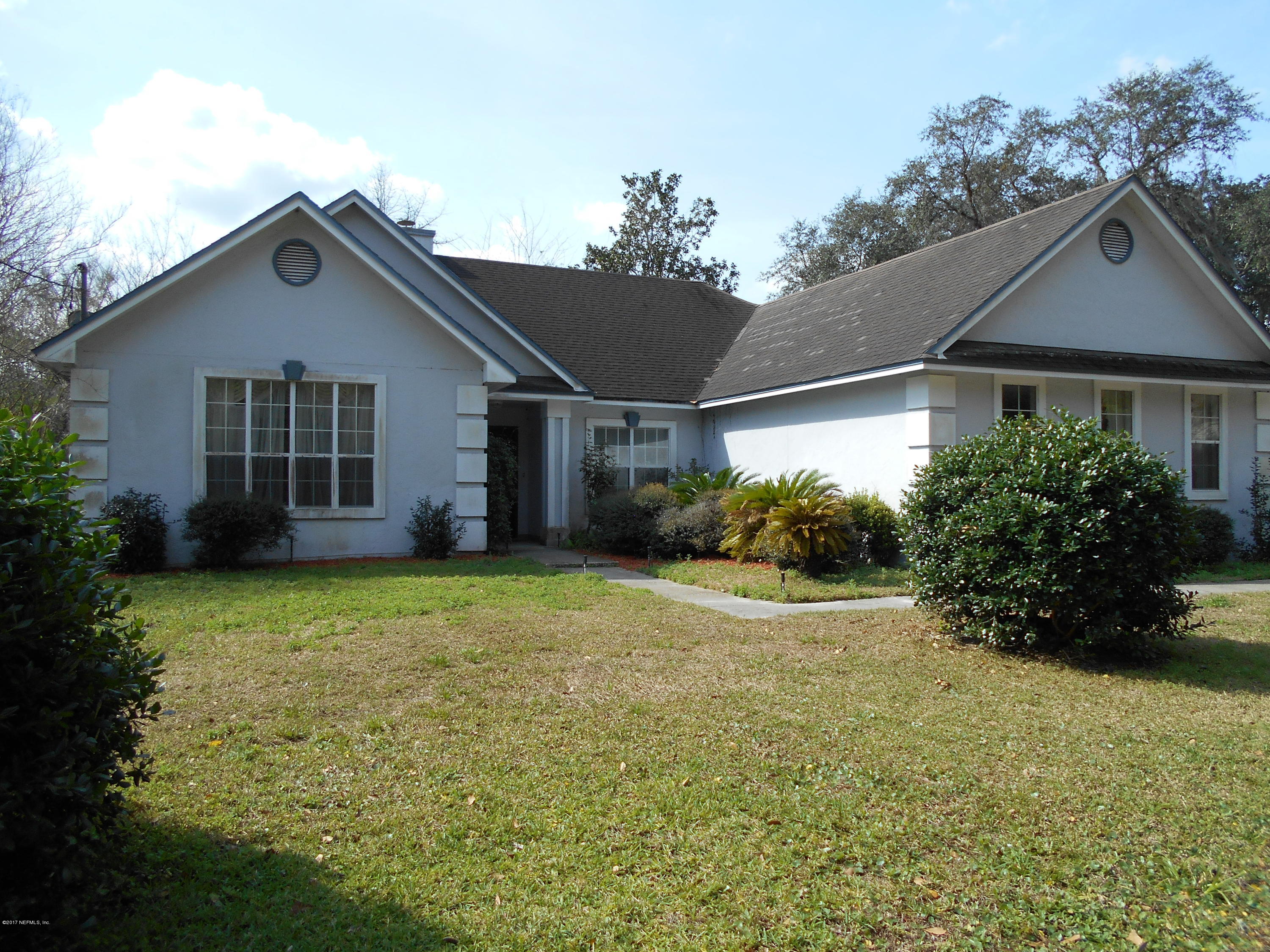 3006 Holly Road Orange Park, FL 32065 - Photo 1 of 19 a front view of a house with a yard and garage