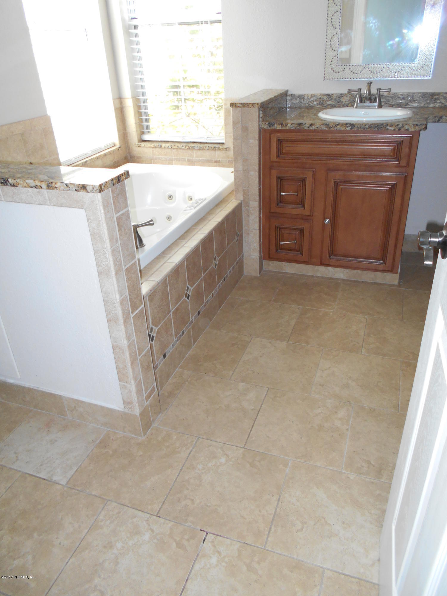 3006 Holly Road Orange Park, FL 32065 - Photo 12 of 19 a bathroom with a granite countertop sink a mirror and a bathtub