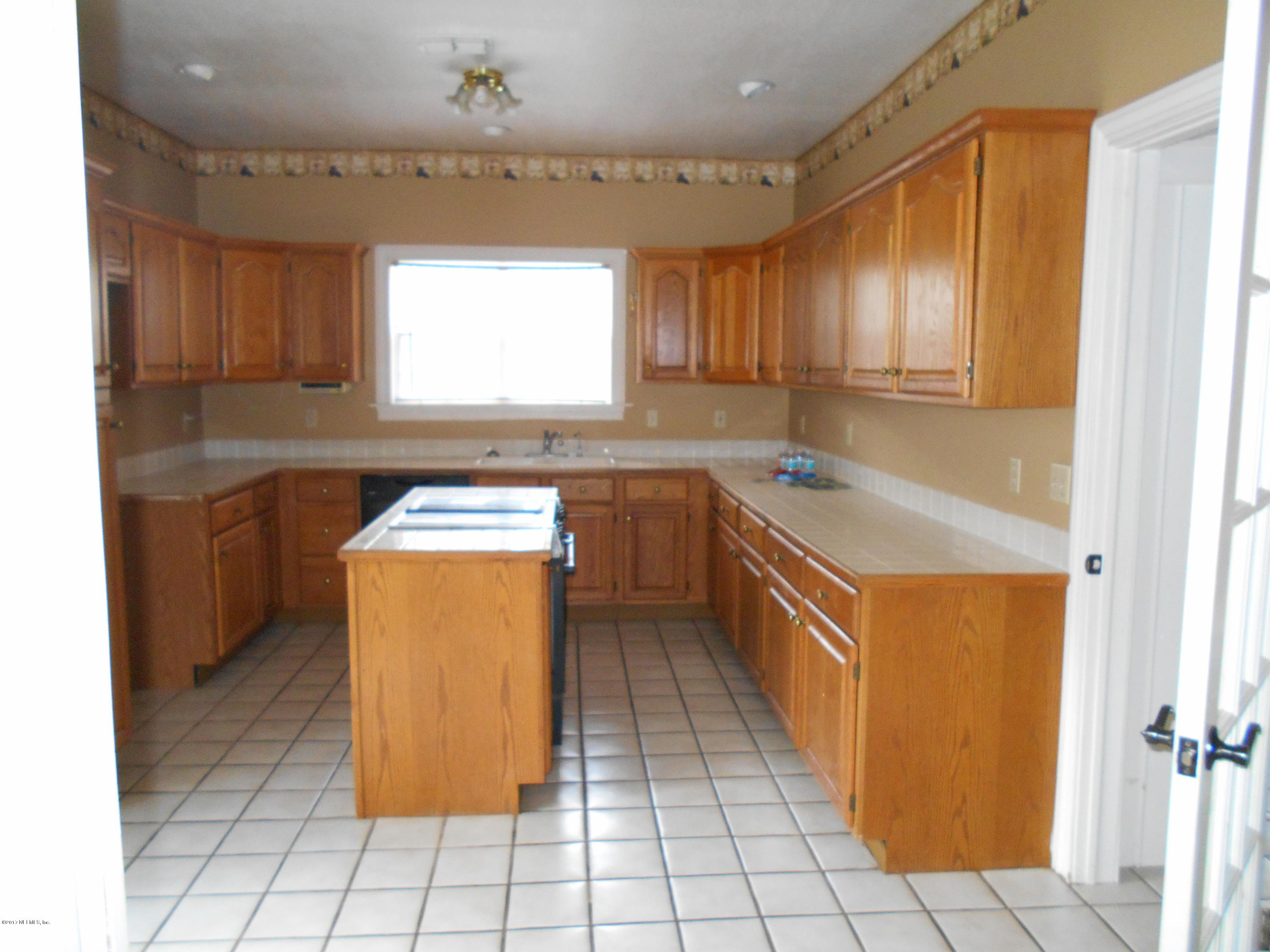 3006 Holly Road Orange Park, FL 32065 - Photo 5 of 19 a kitchen with a sink a counter top space cabinets and stainless steel appliances