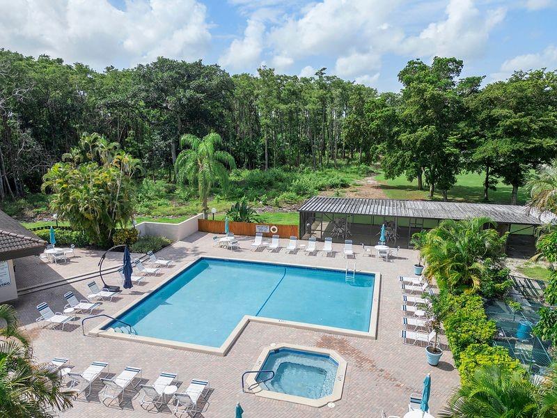 21452 Juego Circle, Unit 31A Boca Raton, FL 33433 - Photo 35 of 38 a view of a patio with couches table and chairs and potted plants