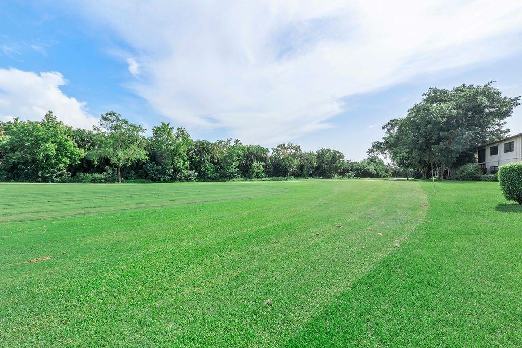 21452 Juego Circle, Unit 31A Boca Raton, FL 33433 - Photo 38 of 38 a view of a green field with wooden fence