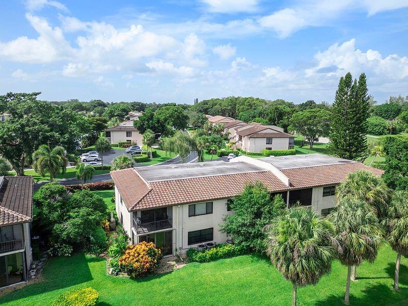 21452 Juego Circle, Unit 31A Boca Raton, FL 33433 - Photo 5 of 38 a view of a house with a big yard plants and large trees