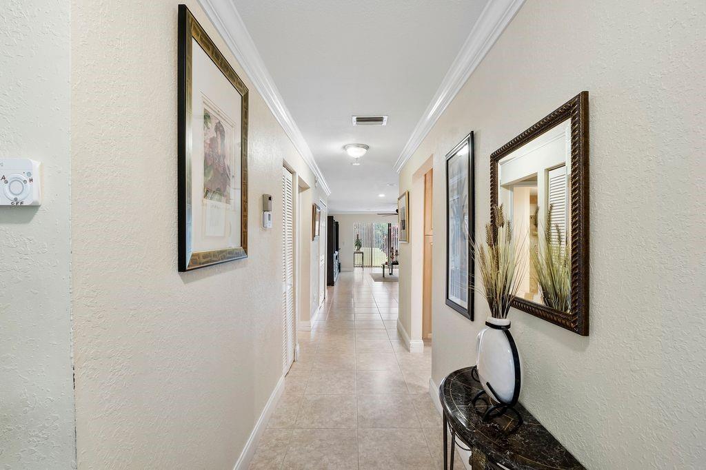 21452 Juego Circle, Unit 31A Boca Raton, FL 33433 - Photo 7 of 38 a hallway with mirror and furniture