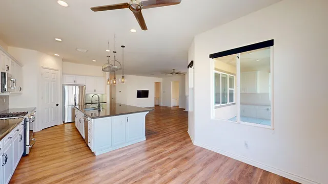 a large living room with wooden floor and a large window