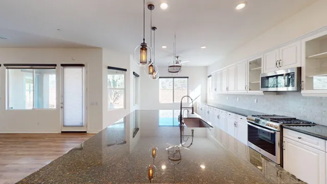 a kitchen with stainless steel appliances granite countertop a stove a sink and a refrigerator