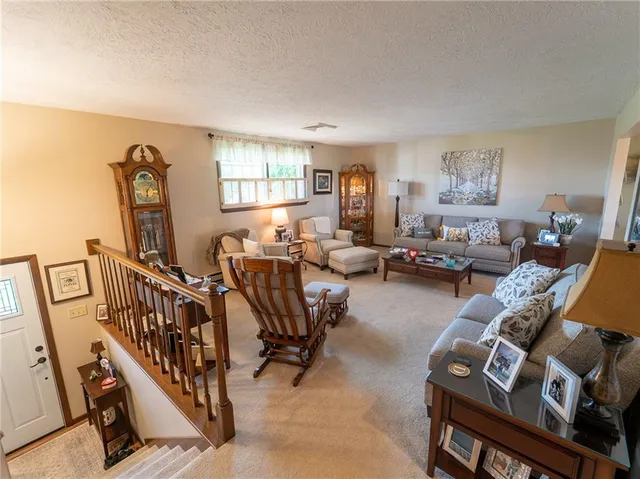 a living room with furniture stairs and a window