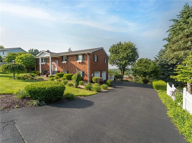 a front view of house with yard and green space