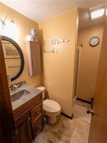 a bathroom with a granite countertop toilet sink and mirror