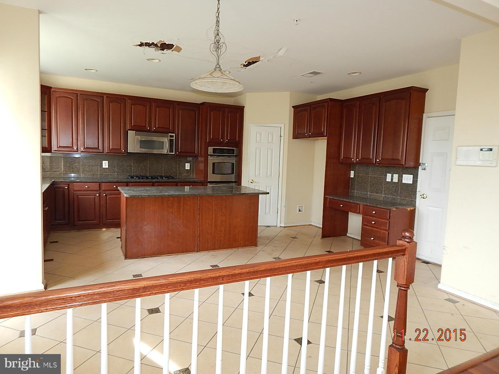 14411 Autumn Rust Road Boyds, MD 20841 - Photo 9 of 30 a kitchen with kitchen island granite countertop a refrigerator a stove top oven a sink and dishwasher