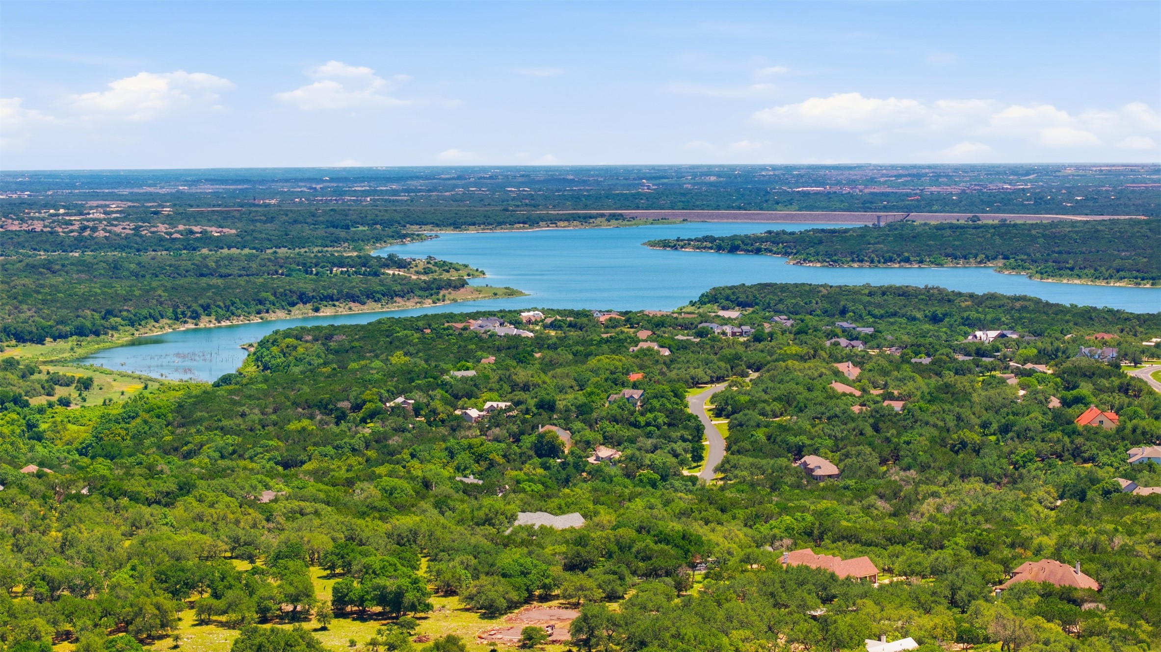 1301 County Road 262 Georgetown, TX 78633 - Photo 8 of 39 Expansive body of water bordered by dense tree coverage, with residential properties interspersed throughout the verdant landscape