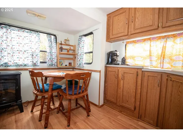 a kitchen with stainless steel appliances granite countertop wooden cabinets a dining table and chairs