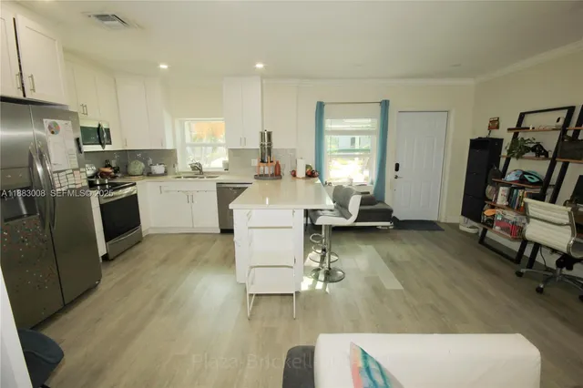 a large kitchen with a table chairs refrigerator and cabinets