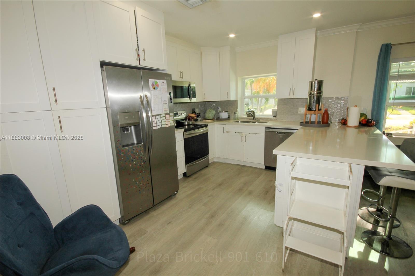2754 Southwest 36th Avenue Miami, FL 33133 - Photo 13 of 35 This kitchen area is designed for efficiency, featuring ample storage and a central island for meal prep or casual dining, making it perfect for cooking and entertaining.