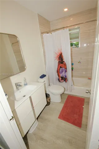 a bathroom with a sink and mirror with bathtub