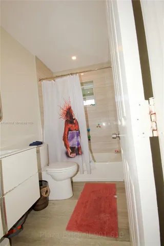 a bathroom with a toilet and a shower curtain