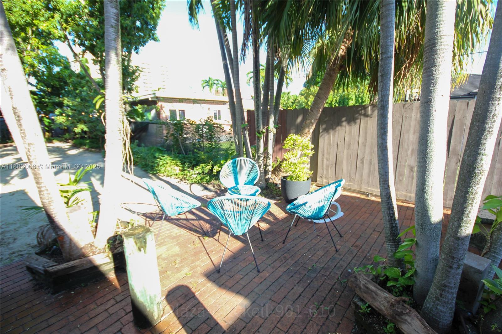 2754 Southwest 36th Avenue Miami, FL 33133 - Photo 26 of 35 This outdoor area is designed for relaxation and socializing, featuring a spacious brick patio surrounded by greenery, perfect for hosting gatherings or enjoying peaceful moments in nature.