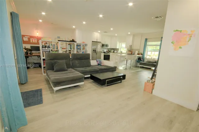 a living room with furniture and kitchen view
