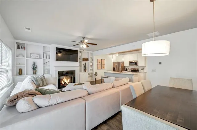 a living room with furniture a fireplace and a flat screen tv